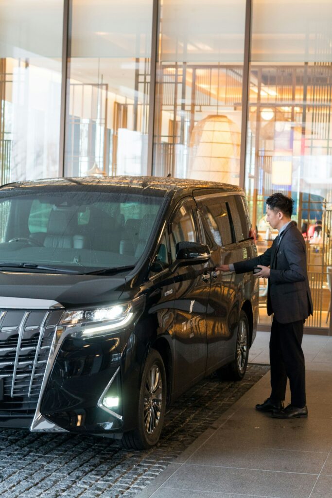 Chauffeur in a suit next to a black car